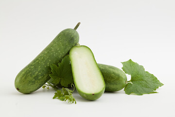 Against a white background, fresh winter melon and green leaf isolated. Winter melon contains a...
