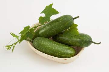 Freshly harvested winter melon placed on a beige basket with green leaf on white background. Winter melon has many health benefits and is widely used in beauty