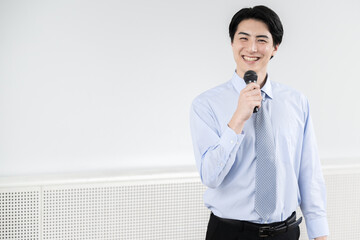 Smiling businessman speaking with microphone Copy space available on left