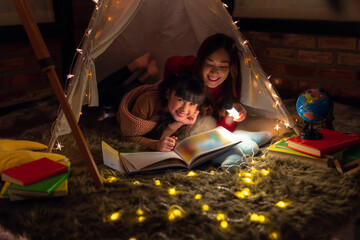 Obraz na płótnie Canvas Asian Mother and daughter relax with tent and light in they bed room