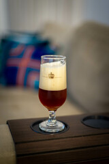 Copo de cerveja sem marca no braço do sofá, casa simples, brasileira