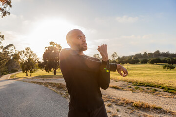 Young, Black man cross-body shoulder stretch during sunset in summer, fitness and workout