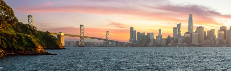 Fototapeta na wymiar Cityscape view of San Francisco and the Bay Bridge with Colorful Sunset from island