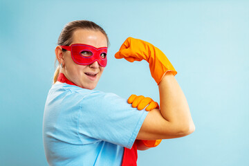 Confidence superhero house cleaner showing her powerful muscle