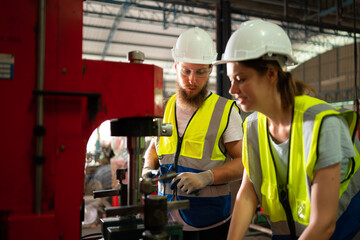 Both of mechanical engineers are checking the working condition of the new machine after completing the installation