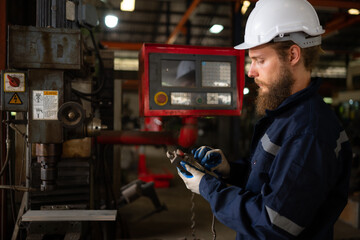 Portrait of mechanical engineers are checking the working condition of an old machine that has been used for some time. In a factory where natural light shines onto the workplace