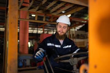 Engineer checks the operation of the forklift truck after the repair is completed. © Wosunan