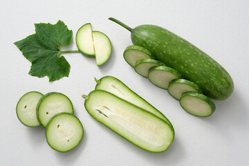 Scene for advertising or branding cosmetic product with ingredient from winter melon (Benincasa hispida). Some slices of fresh winter melon and green leaf decorated on a white background.