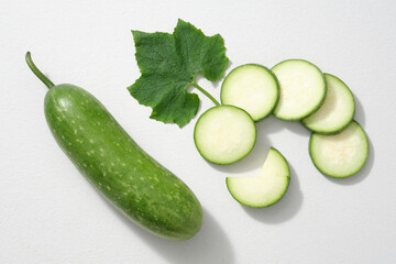 Advertising scene for a food that is also considered a fruit with many health benefits - winter melon (Benincasa hispida). Leaf, some slices and fresh winter melon isolated on a white background.