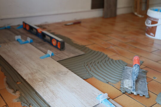 Pose de carrelage au sol dans une maison par un artisan