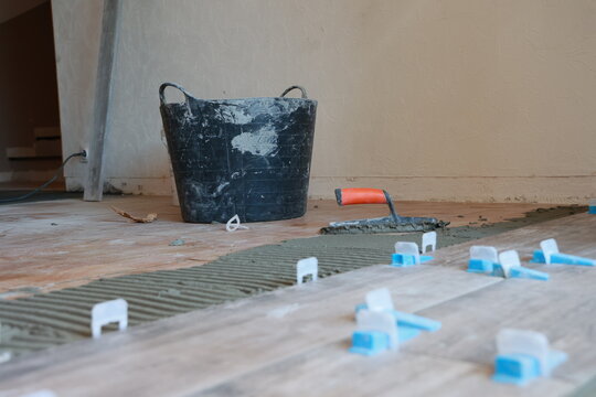 Pose de carrelage au sol dans une maison par un artisan