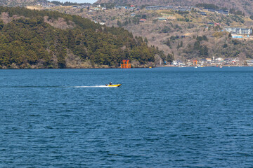芦ノ湖の青い湖面を疾走する小さなボート