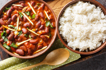 Rajma Or Razma is a popular North Indian Food, consisting of cooked red kidney beans in a thick gravy with spices served with rice close-up on a wooden tray. Horizontal top view from above