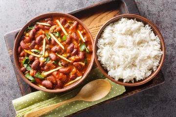 Fotobehang Rajma Masala is a popular North Indian dish made with red kidney beans and rice close-up on a wooden tray on the table. Horizontal top view from above © FomaA
