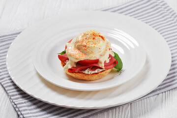 Eggs Benedict on white plate, top view