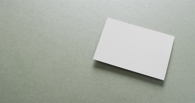 Close up of stack of white business cards on grey background, copy space, slow motion