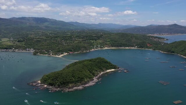 Aerial drone video of tropical paradise exotic Cu Mong lagoon, Nhat Tu Son island covered in limestone trees with emerald crystal clear beach and Lobster farm in Phu Yen, Vietnam
