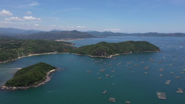 Aerial drone video of tropical paradise exotic Cu Mong lagoon, Nhat Tu Son island covered in limestone trees with emerald crystal clear beach and Lobster farm in Phu Yen, Vietnam
