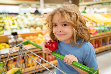 Shopping, discount, sale concept. Kid boy with shopping basket. Child at store. Supermarket and grocery shop concept. Little child customers buying products at supermarket.