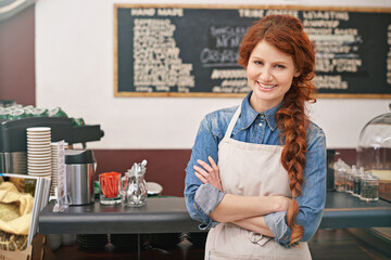 Portrait, woman and barista with arms crossed, coffee shop and startup success with skills. Face,...