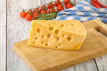 Maasdam cheese piece over board