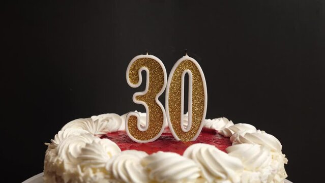 A candle in the form of the number 30, inserted into the holiday cake, is blown out. Celebrating a birthday or a landmark event. The climax of the celebration.
