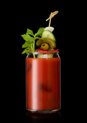 Cocktail with vodka and juice bloody mary with pickle and olive on black background.