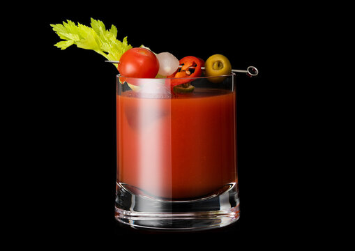 Classic hot bloody mary cocktail mix with vodka and tomato juice on black background.