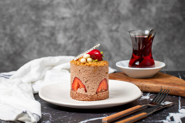 Strawberry, Croquant and Pistachio Cake. Delicious cream cake on dark background