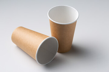 Disposable cardboard biodegradable cups on a white table, gray background.