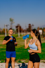 Fitness couple is about to drink some water while having a conversation