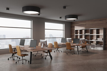 Stylish office coworking interior with pc computer on table, shelf with window