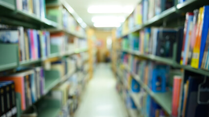 Blurred public library interior with aisle of bookshelf with textbooks and literature. Education, knowledge learning and background