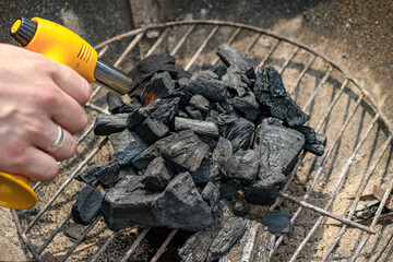 Rozpalany, palnikiem ręcznym gazowym, w palenisku grilla ekologiczny węgiel drzewny 