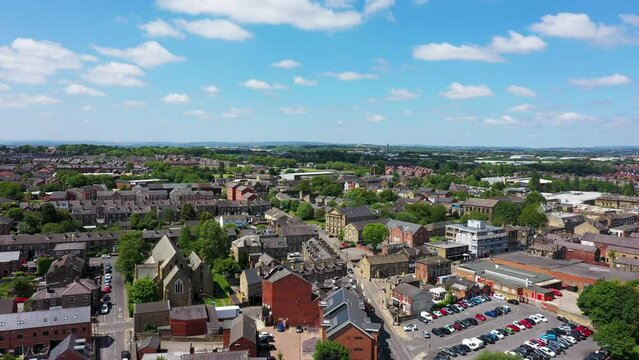 Aerial drone footage of the town of Morley in Leeds West Yorkshire, England showing the beautiful British town main street and housing estates from above on a sunny summers day.
