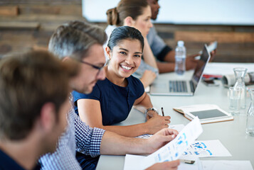 Portrait, happy and a business woman in the boardroom with her team during a meeting for planning. Smile, strategy or collaboration with a female employee and colleagues in the office for a workshop