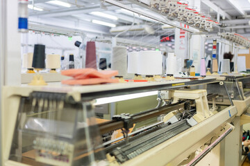 sewing machine pictures Clothes are being made with natural materials, with mechanisms, devices and spools of colorful threads on top, working in a large weaving factory.