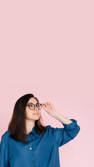 Thoughtful Woman in Glasses, Touching Her Frames, Deep in Contemplation, Searching for Ideas in...
