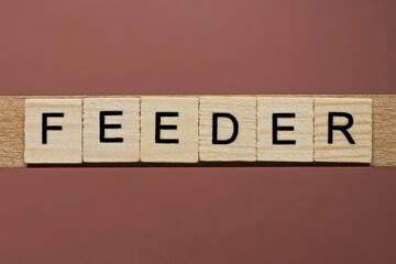 gray word feeder made of wooden square letters on brown background