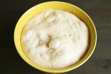 Closeup of fluffy risen dough in a mixing bowl