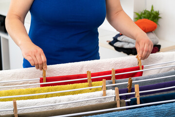 Young woman hanging clothes on clothesline at laundry room