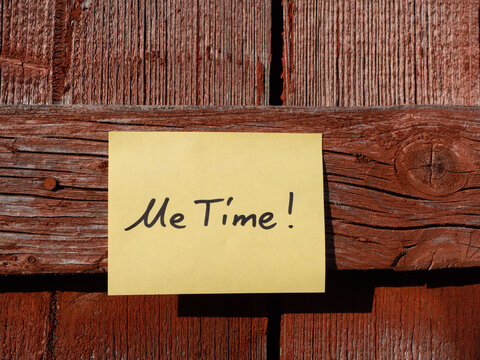 Yellow Sticky Note on Red Weathered Wooden Facade with Handwritten Me Time Message. Close Up. Frontal View.