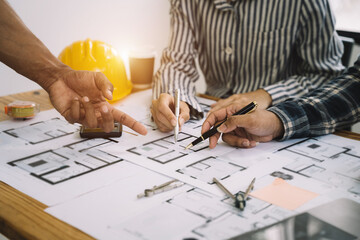 Person's engineer Hand Drawing Plan On Blue Print with architect equipment, Architects discussing...