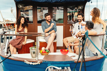 Friends Celebrating on the Boat with Fruit and Champagne - A group of friends relaxes on the back...