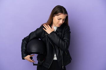 Young caucasian woman holding a motorcycle helmet isolated on purple background suffering from pain in shoulder for having made an effort