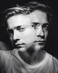 Chaotic thoughts displayed with a double exposure of a man in a dark room.