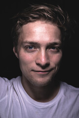 Close up of a man pondering in a dark room