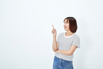 Portrait of smiling attractive asian female in casual t-shirt pointing finger upper