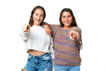 Friends girls over isolated chroma key background points finger to the front