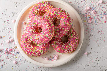Fresh and yummy pink donuts topped with sprinkles.